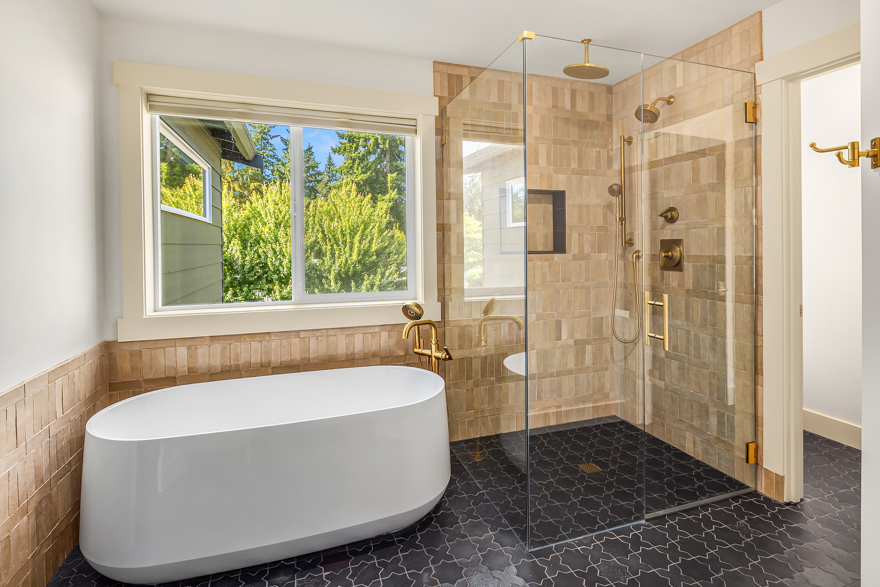 Freestanding tub beside a zellige-tiled walk-in shower