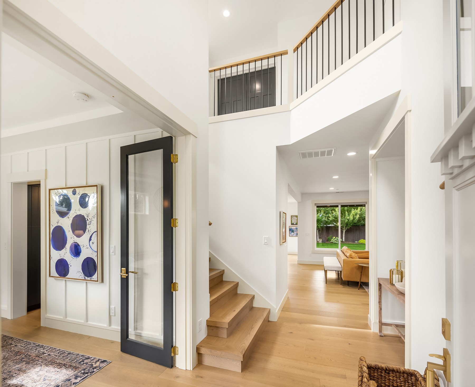 Entry hall with board and batten walls and white oak stair
