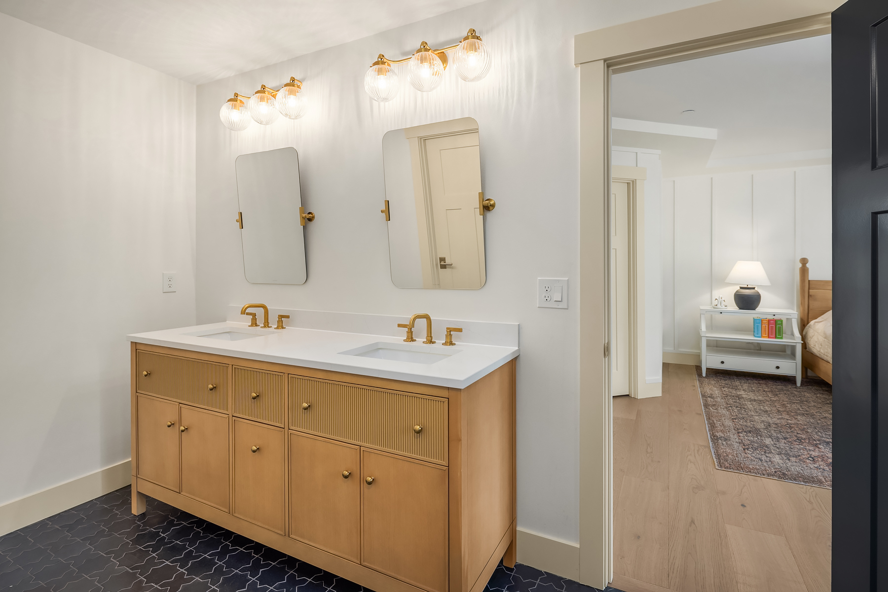 Double vanity in fluted white oak with brass sconces