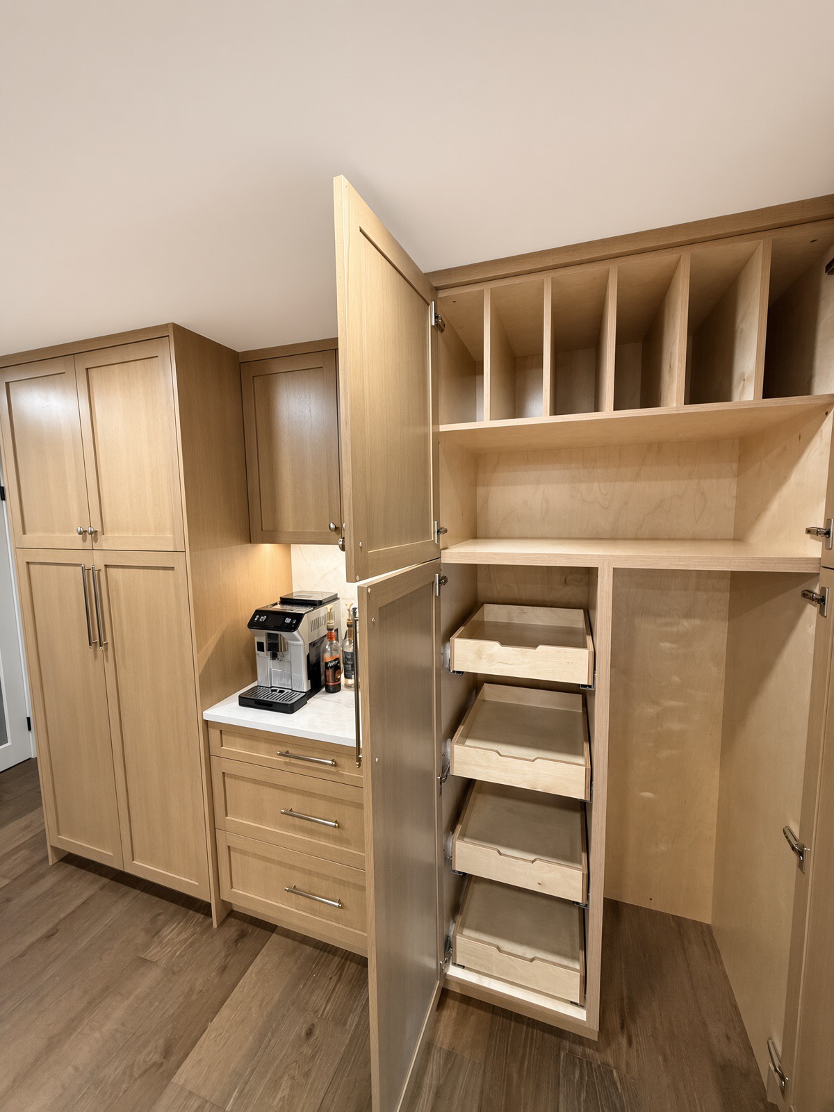 Open custom white oak pantry with tray dividers and pull-out drawers